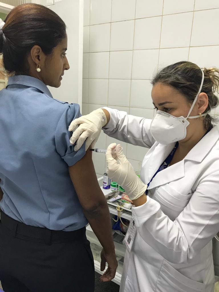 Agente da Coordenadoria de Saúde aplicando a vacina da gripe. 